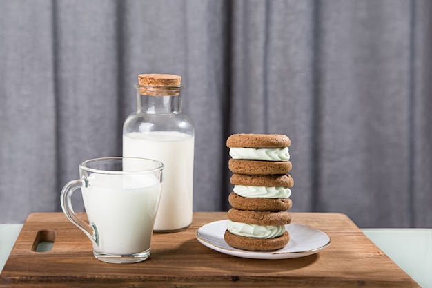 Milk jugs and cookies on gray background