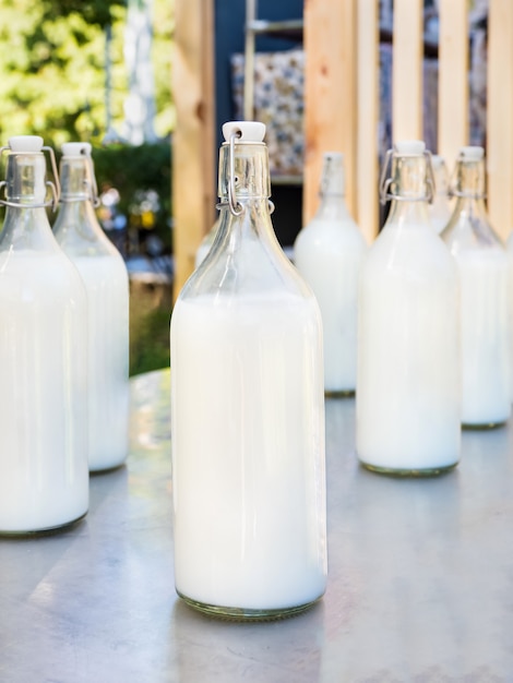 Milk in large glass bottles on grey table