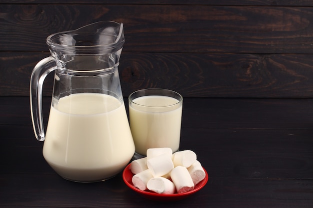 Milk and marshmallows on a dark surface