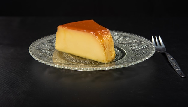 Milk pudding in a glass dish on a dark surface