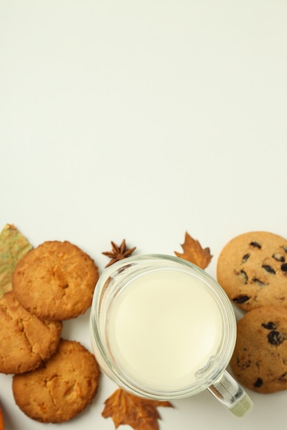 Milk and pumpkin cookies on white background..