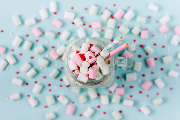 Milk  shake with Marshmallows  in a glass jar on a blue background