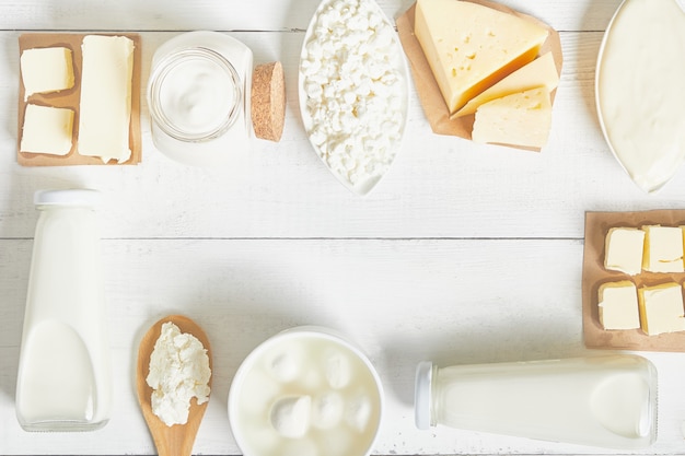 Milk, sour cream, mozzarella, kefir, yogurt, butter, cheese assortment. Flat layout. Text space.