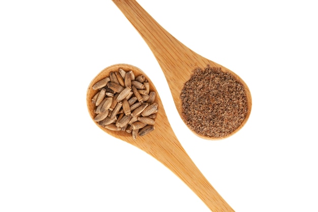 Milk Thistle powder and Silybum marianum seeds in wooden spoons on white background Herbal superfood