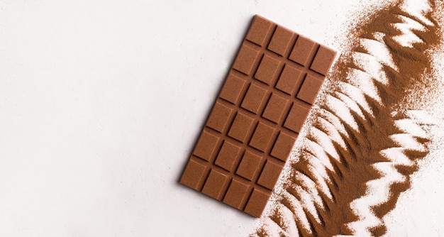 Cioccolato al latte vegano su sfondo bianco. copia spazio. vista dall'alto