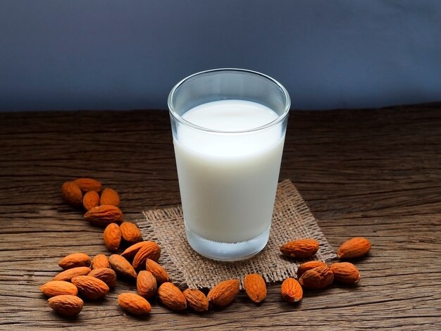 Milk with almonds on wooden background