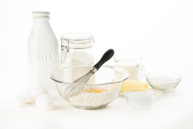 Milk with eggs and flour on white background