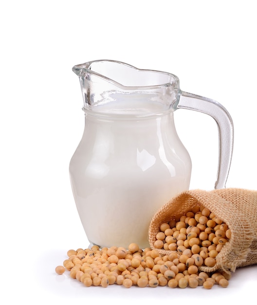 Milk with soy beans on white wall