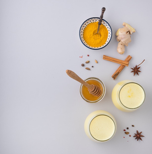 milk with turmeric and honey on gray background