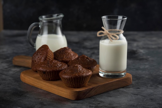 Milk on wooden cutting board with sweety cacao chocolate cooikies