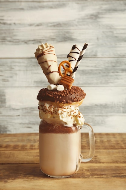 Photo milkshake donut and other sweets in jar on wooden table