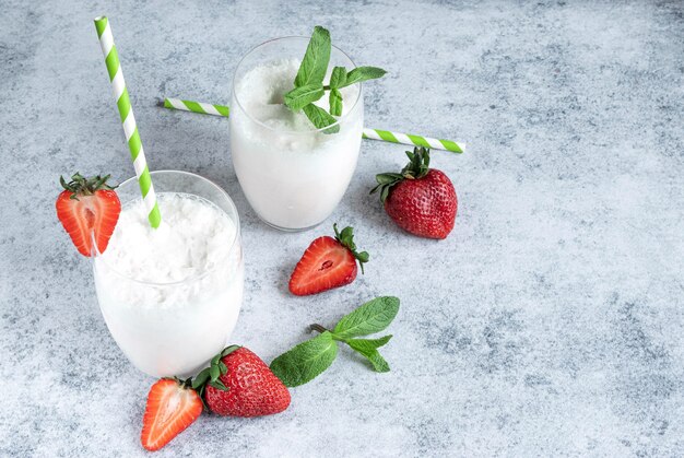 Milkshake in twee glazen en verse aardbeien