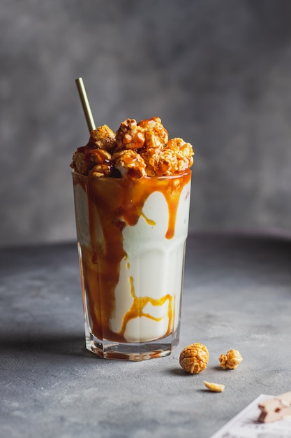 Milkshake with caramel sauce decorated by popcorn