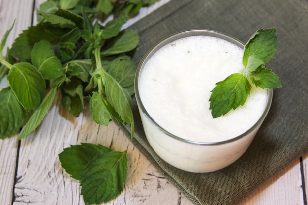 Milkshake with ice cream and mint on wooden background