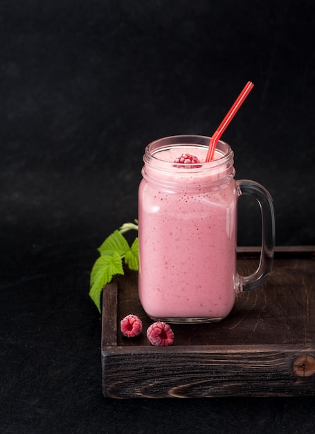 Milkshake with raspberries in a glass jar