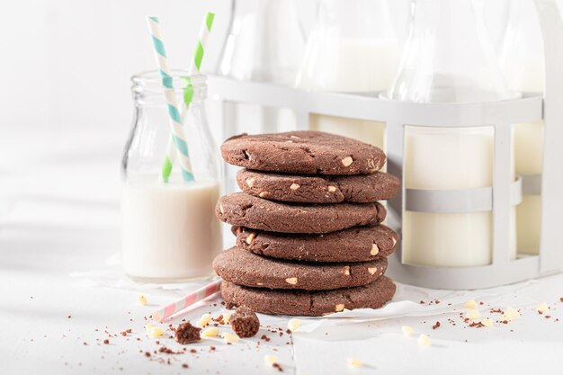 Foto biscotti al cioccolato lattiginosi e croccanti serviti con latte in bottiglia