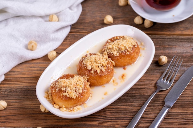 Milky kemalpasa dessert Dessert with milk and hazelnuts on wooden background Traditional Turkish cuisine Closeup local name sutlu kemalpasa tatlisi