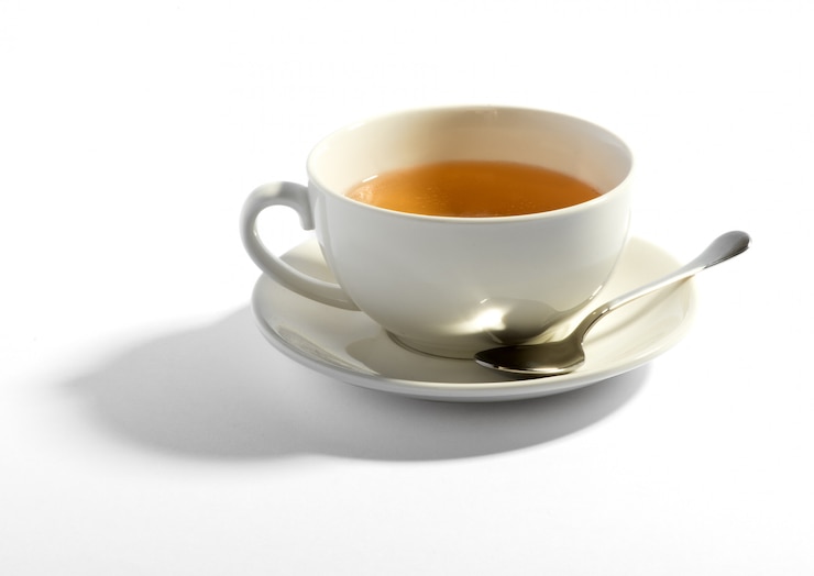 Photo milky tea in a cup with a teaspoon