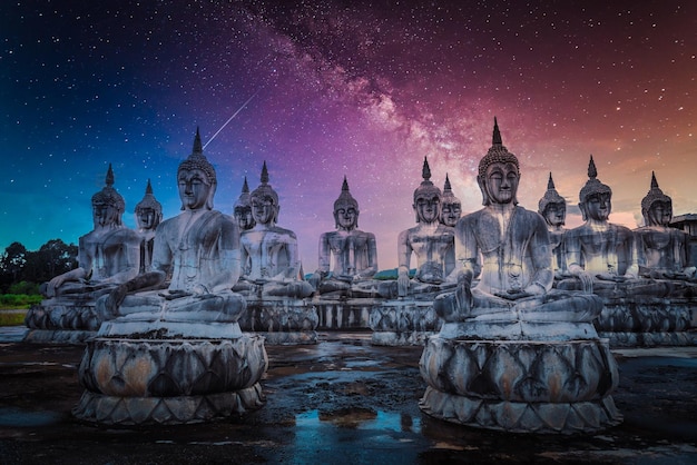 Milky way over many Statue buddha image at night in southen of Thailand