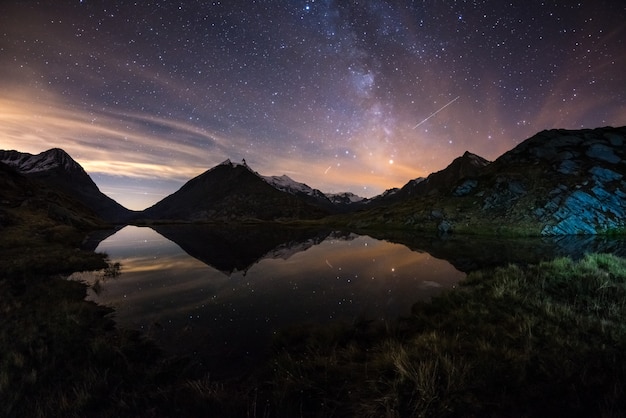 Milky Way starry sky reflected on lake at high altitude on the Alps