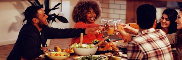 Millennial adult friends celebrating Thanksgiving together at home