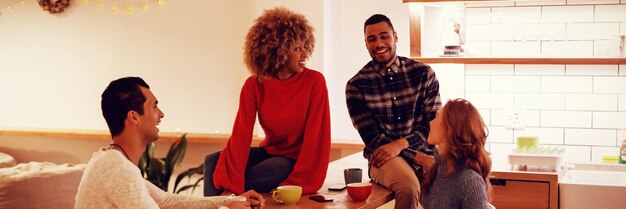 Millennial adult friends socialising together at home