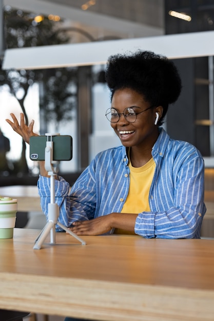 Millennial african american woman in a public place watching a webinar or chatting on a webcam from