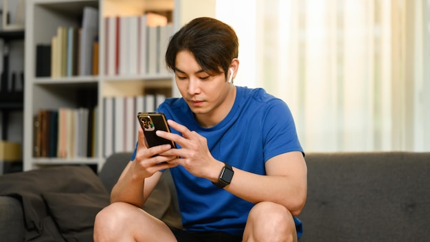 Тысячелетний азиатский мужчина отправляет текстовые сообщения в чате в социальных сетях на смартфоне Концепция технологии связи людей