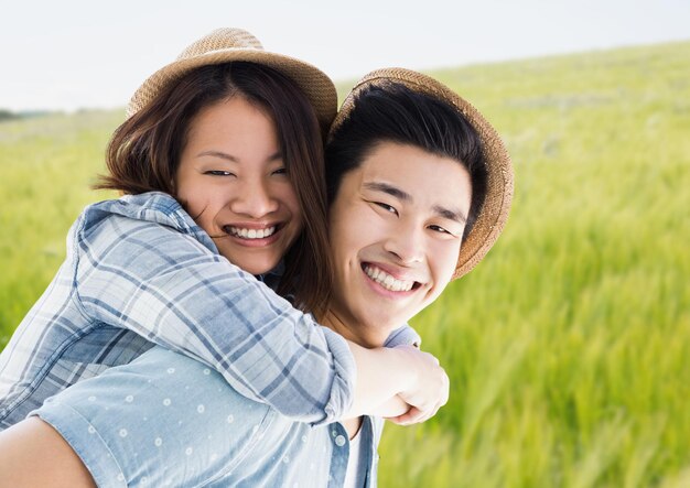 Photo millennial couple piggy back against blurry meadow