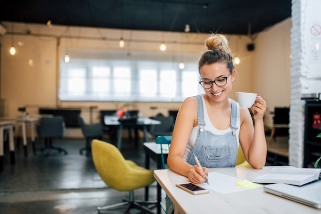 Millennial girl making notes.