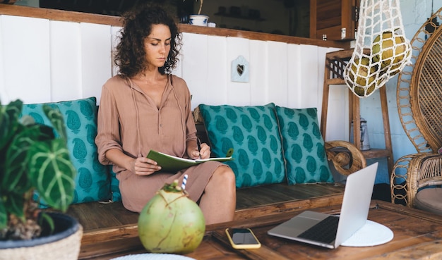 Millennial vrouwelijke freelancer met digitale laptop computer schrijven organisatie ideeën in notepad blanke vrouw met moderne netbook technologie maken informatieve aantekeningen in planner leerboek