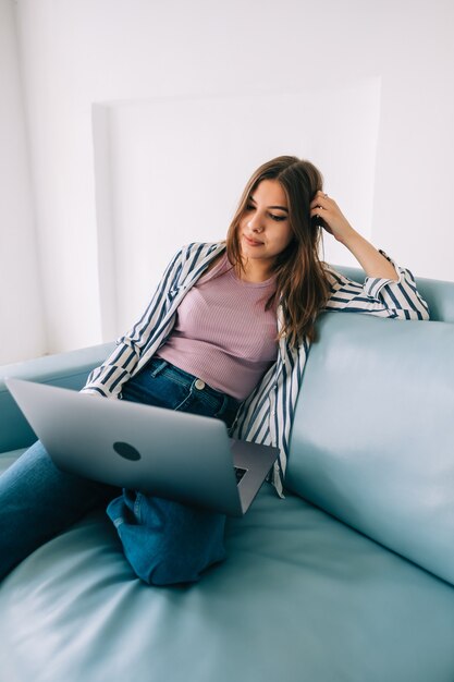 Millennial woman sit at home and work on laptop