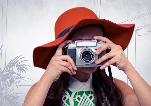 Donna millenaria con cappello da sole e fotocamera contro l'ufficio bianco disegnato a mano