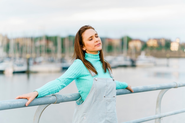 Millennial young adult woman enjoying sunset light and fresh air feeling free