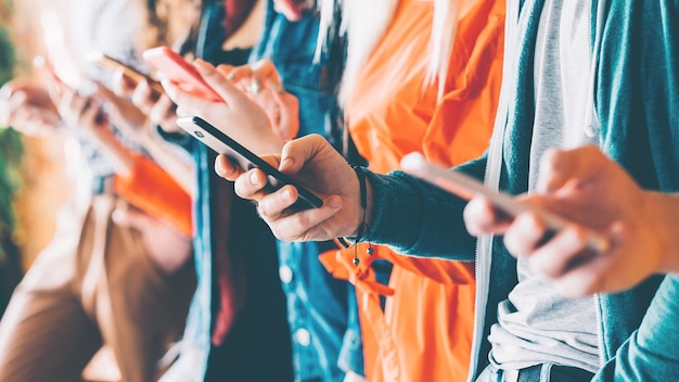 Millennials in het digitale tijdperk Bijgesneden close-up van smartphones in handen van jonge mensen Jongeren verslaafd aan sociale netwerkdiensten