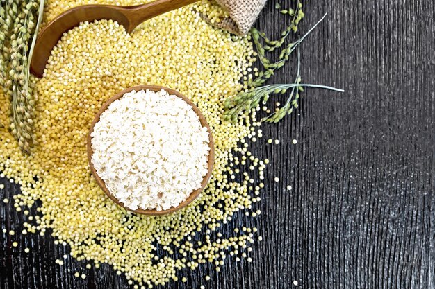 Millet flakes in bowl on board top