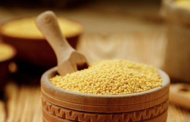 Millet polished in bowls and bags on a wooden background High quality photo