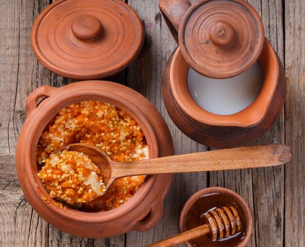 Millet porridge with pumpkin and milk in a clay pot