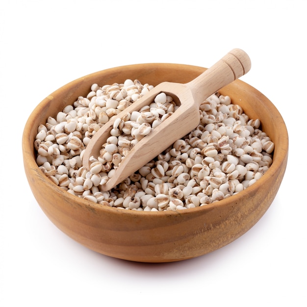 Millet rice in a wooden bowl isolated on white background