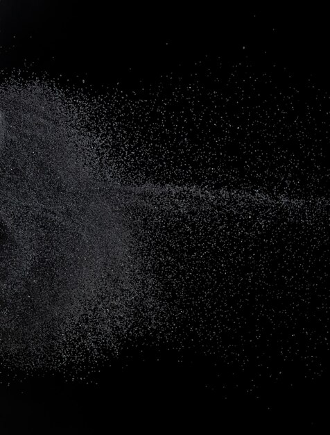 Million of black sand explosion Photo image of falling down sands flying Freeze shot on black background isolated overlay Tiny Fine sand dust magnet as particle disintegrate science