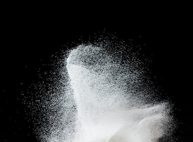 数百万の白い砂の爆発、降り注ぐシャワー雪、大雪嵐の飛行の写真画像分離された黒の背景にフリーズ ショット オーバーレイ粒子科学としての小さな細かい塩の砂
