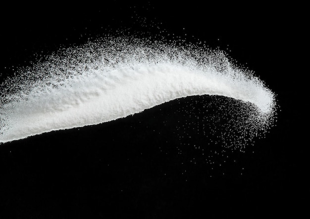 数百万の白い砂の爆発、降り注ぐシャワー雪、大雪嵐の飛行の写真画像分離された黒の背景にフリーズ ショット オーバーレイ粒子科学としての小さな細かい塩の砂