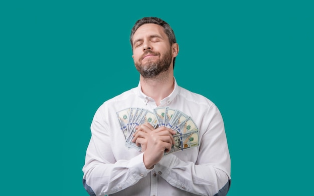 Millionaire holding money cash photo of sleepy millionaire with money dollars millionaire with money isolated on blue background millionaire hold money in studio