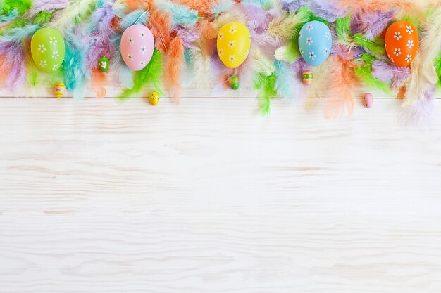 Photo milticolor bird feathers and easter eggs decoration. easter concept.