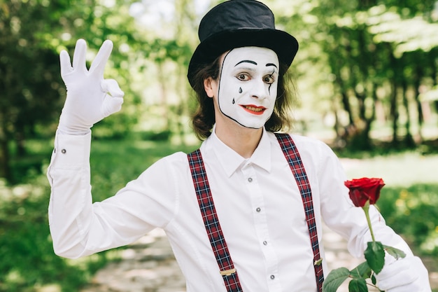 Mime met rode roos in een park