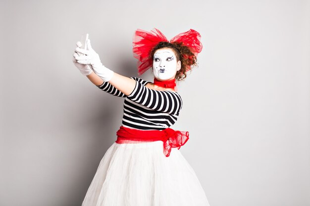 Mime taking a selfie photo. Woman with smartphone. Concept of April Fools Day.