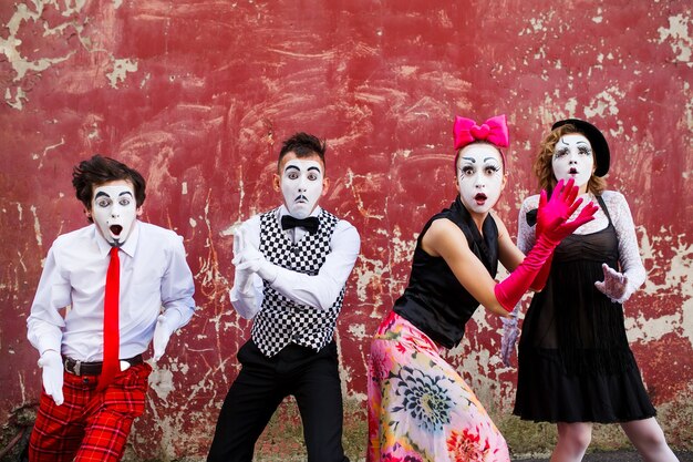 mimes standing on a red wall