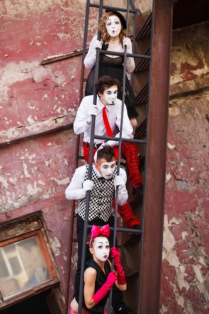 mimes standing on a red wall