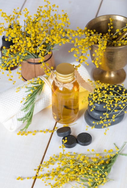 Mimosa bloemen massageolie in glazen fles. Detailopname