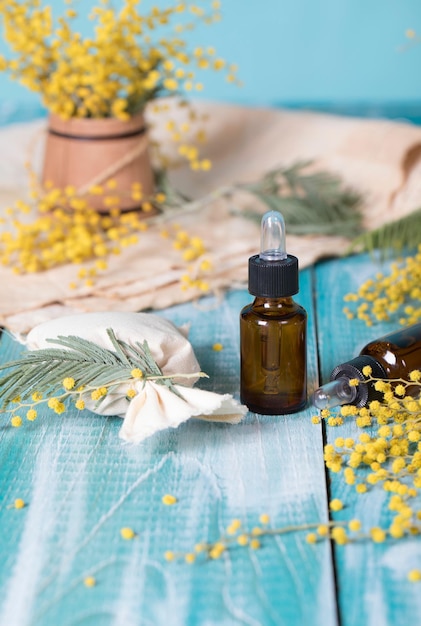 Mimosa essential oil on a wooden surface.